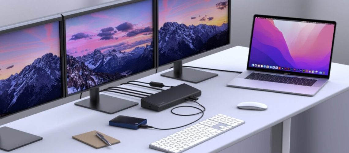 Biurko z laptopem podłączonym do dodatkowych monitorów i sieci przez stację dokującą USB-C.